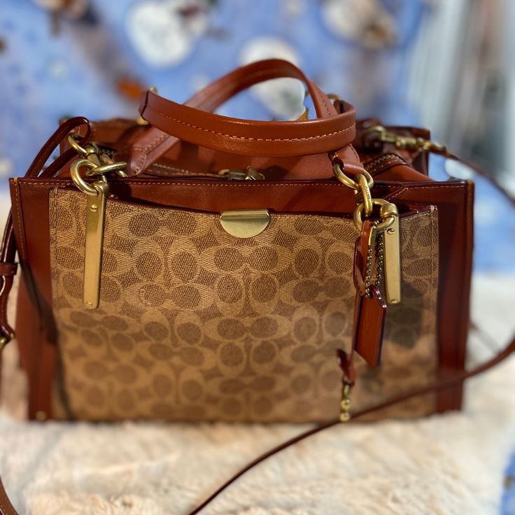 This Coach Cc Sig Bag Is Brand New. I Cut The Tags Off When I Got It But Never Used It. It Is In Impeccable Condition.The Gold Hardware Is Shiny With No Scratches Whatsoever. This Is A Beautiful Large Bag. It Can Be Worn On The Shoulder And As A Handbag. I Am A Purse Fanatic And Need To Downsize. All Of My Listings Were Purchased By Me And Are From My Personal Closet So I Know Their History. There Are No Rips, Holes Or Stains Unless Otherwise Noted And Come From A Clean, Smoke-Free, Pet Friendly High-end Brown Satchel With Adjustable Strap, High-end Brown Crossbody Shoulder Bag, High-end Brown Shoulder Bag With Adjustable Strap, High-end Brown Satchel With Branded Hardware, High-end Beige Shoulder Bag With Branded Hardware, High-end Beige Crossbody Shoulder Bag, Brown Handheld Bags With Branded Hardware, Brown Handheld Bag With Branded Hardware, Luxury Light Brown Shoulder Bag With Gold-tone Hardware