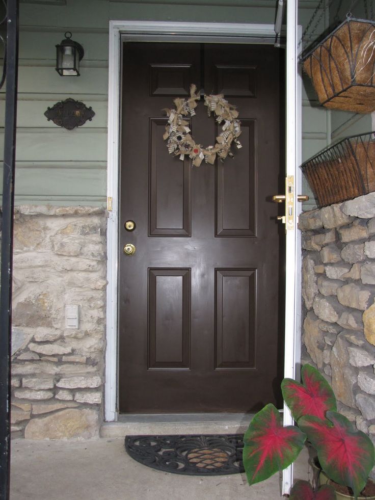 a brown front door with a wreath on it