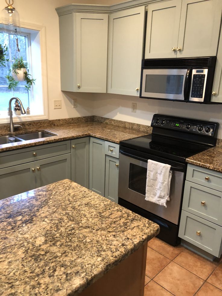 a kitchen with granite counter tops and stainless steel stove top oven, microwave, dishwasher and sink