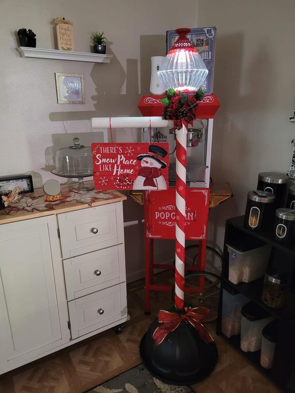 a candy cane stand in the corner of a room with christmas decorations on it and other items