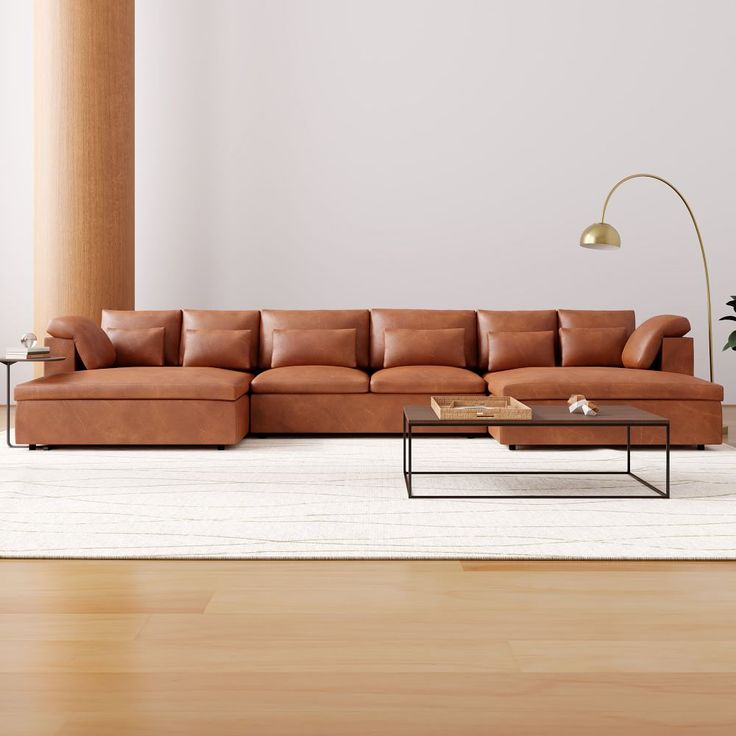 a living room with a couch, coffee table and lamp on the floor in front of it