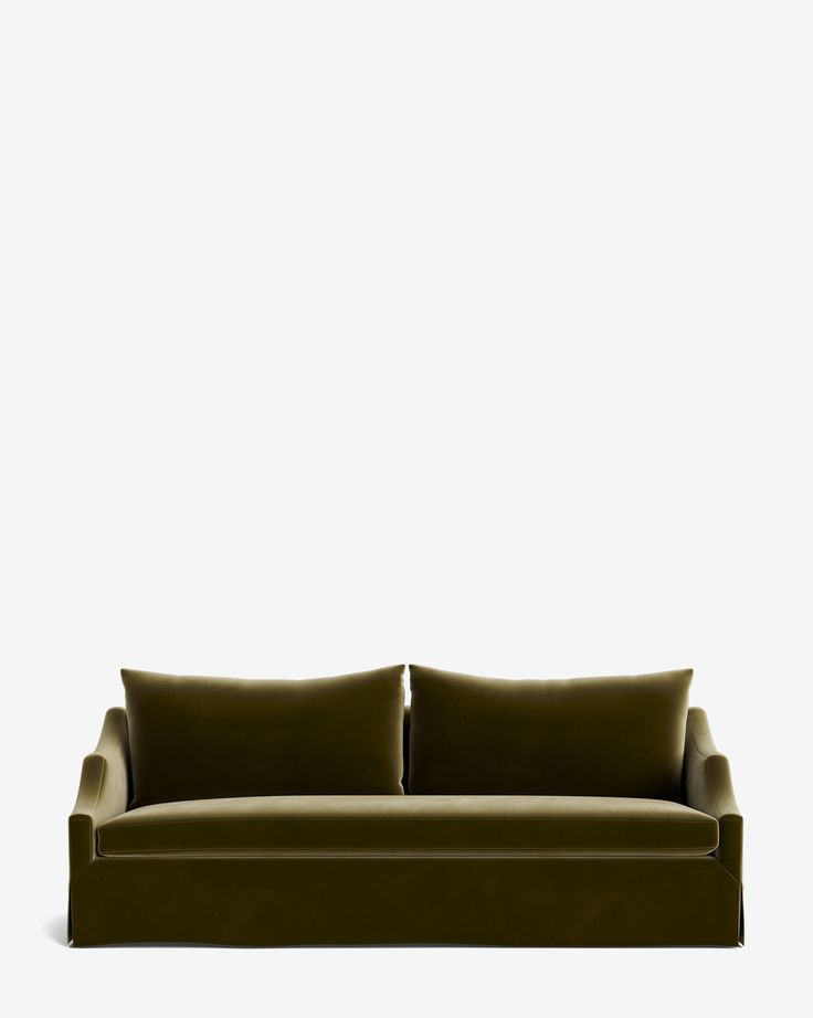 a green couch sitting on top of a white wall