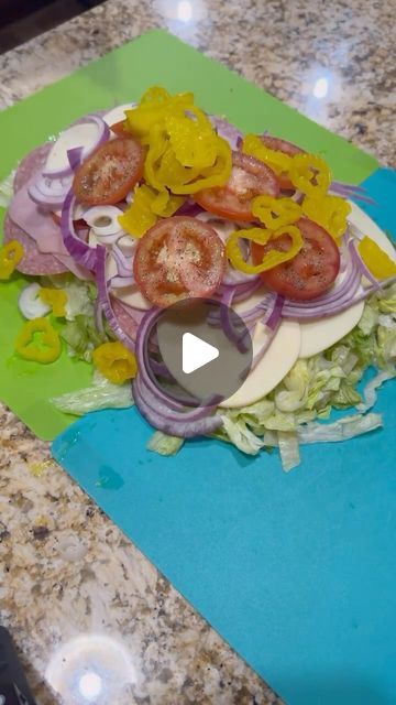 a cutting board topped with onions, tomatoes and onion slices on top of a counter