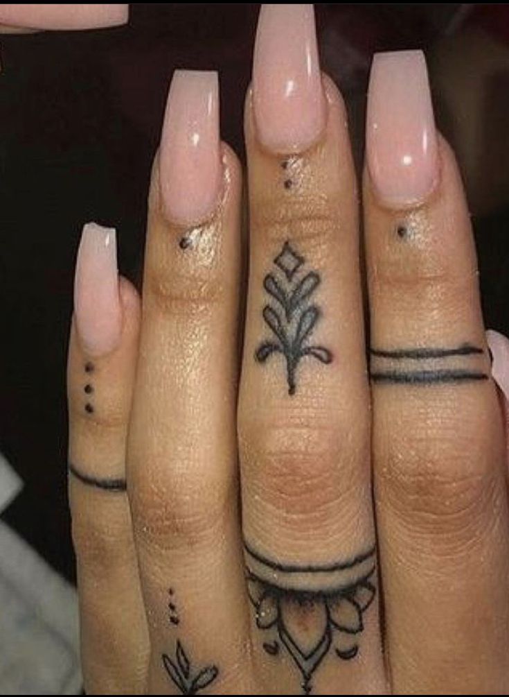 two fingers with tattoos on them, one is pink and the other has black ink