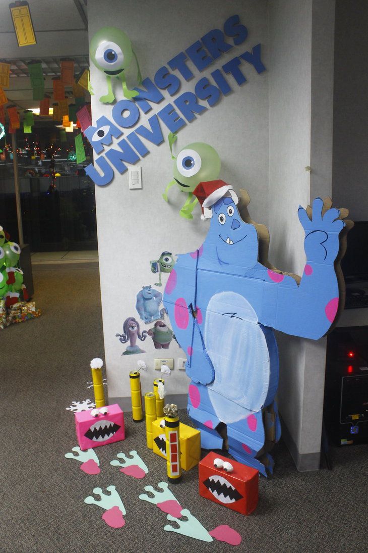 an office decorated for christmas with monsters on the wall and toys in front of it