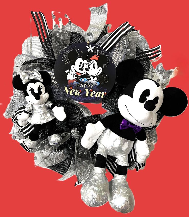 mickey and minnie mouse wreath with happy new year tag on it, against a red background