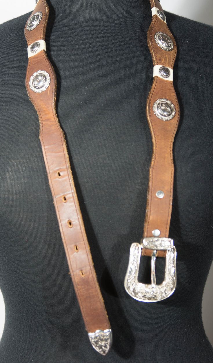 Here is a brown leather belt with silver tone metal concho embellishments and a southwestern pattern with a silver color metal buckle. You'll love its rodeo ranch style. And you'll love pairing it with your favorite western jeans, denim dresses or skirts. This belt is in overall good condition with signs of wearing; scuffing and use and it's very collectible with the DUN DEE brand stamp that's made in Texas, USA. It's stamped a size 32. Check out photos for this belt and check out its measuremen Southwestern Style Concho Belt For Festivals, Southwestern Concho Belt Buckles For Ranch, Western Antique Belt Buckles For Festival, Leather Concho Belts For Western-themed Events, Southwestern Concho Belt For Western-themed Events, Adjustable Brown Belts With Silver Buckle, Adjustable Brown Belt With Silver Buckle, Brown Adjustable Belt With Silver Buckle, Southwestern Leather Belt Buckles For Rodeo