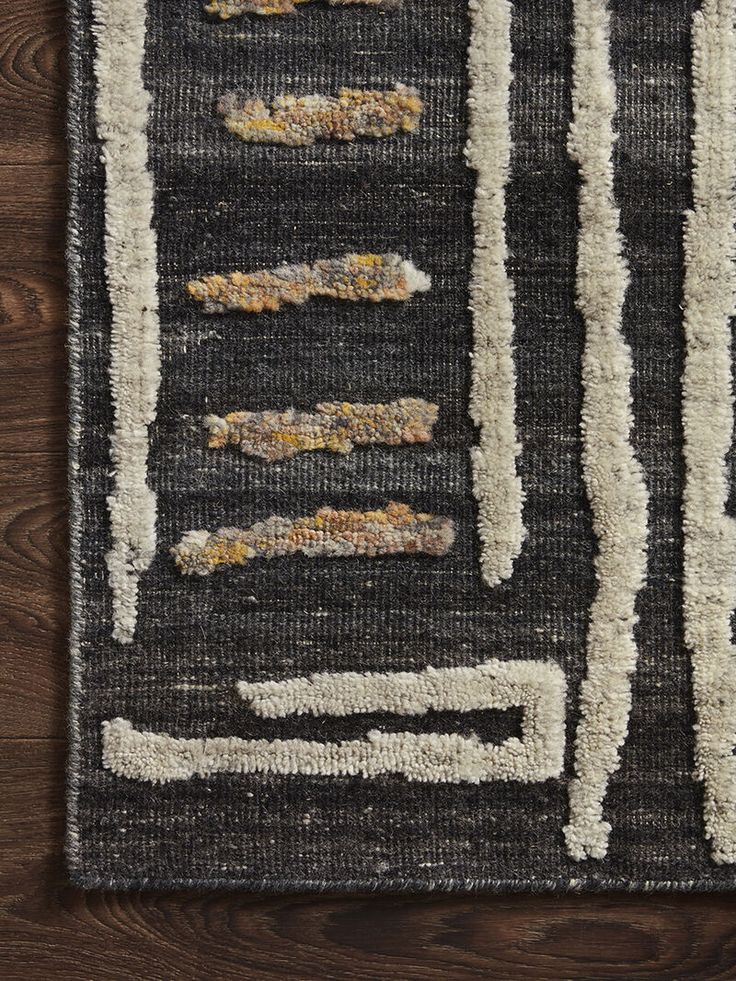 a black and white area rug on a wooden floor with wood grains in the background