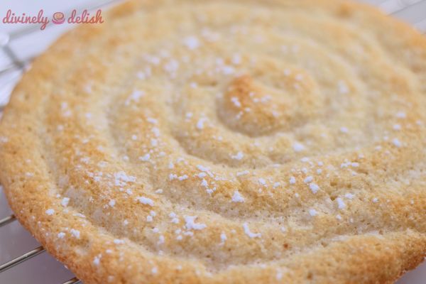 a close up of a cake on a cooling rack with powdered sugar sprinkles