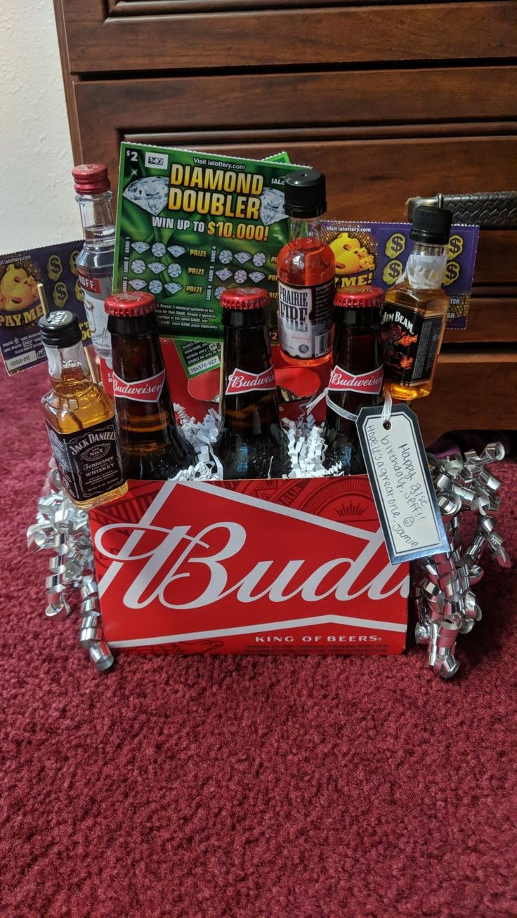 a bud can is sitting on the floor in front of a bed with other items