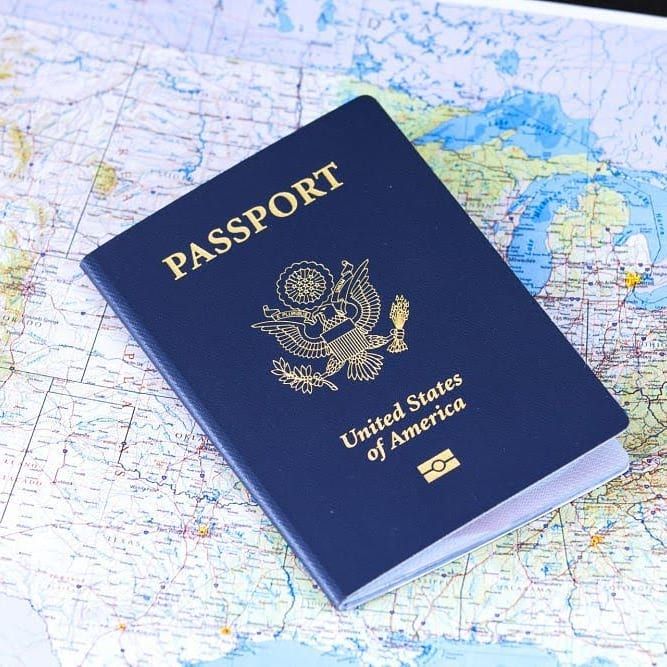 a blue passport sitting on top of a map