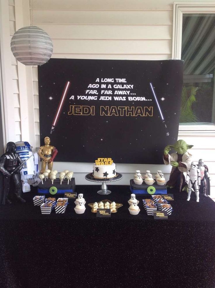 a star wars themed birthday party with desserts and decorations on a table in front of a sign