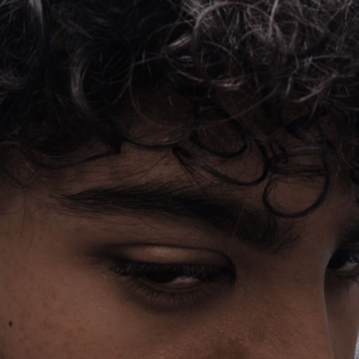 a close up of a man's face with frizz on his hair