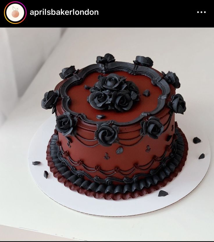 a red and black decorated cake sitting on top of a table