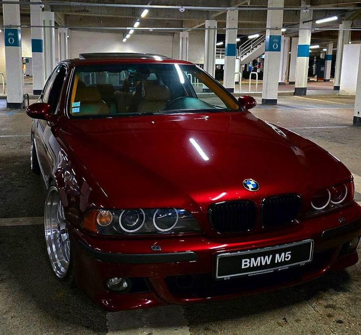 a red bmw m5 parked in a parking garage