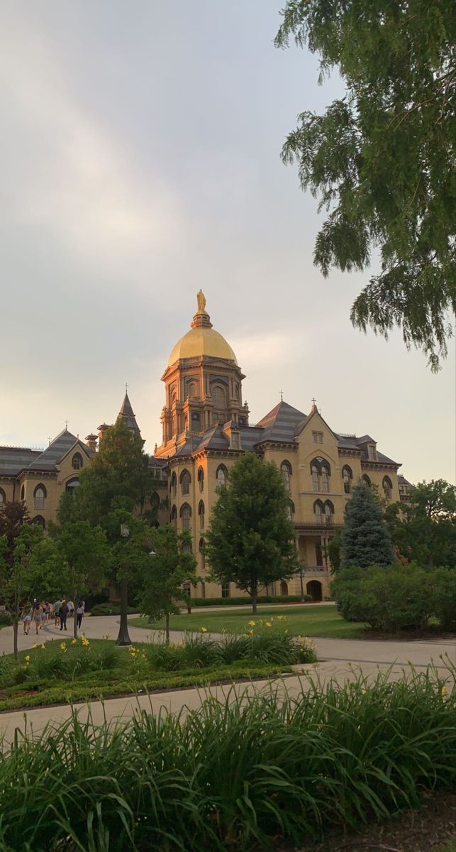 a large building with a golden dome on it's roof surrounded by greenery