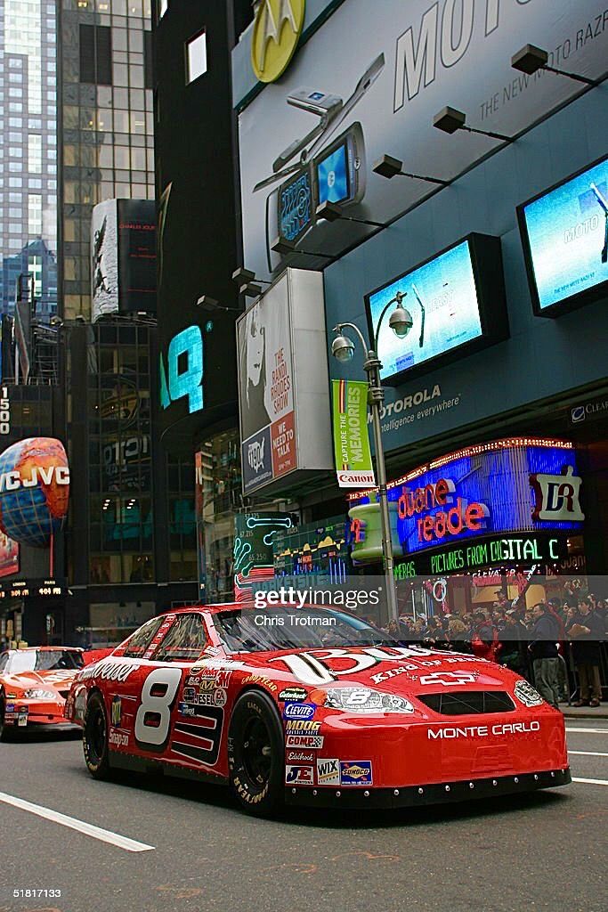 a race car driving down the street in times square