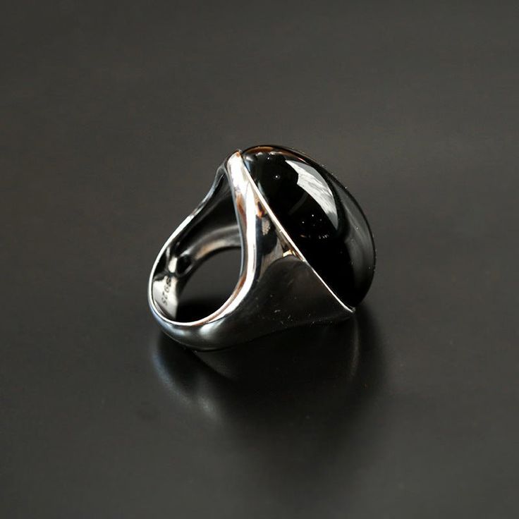 Introducing our captivating 925 Silver Black Onyx Oval Egg Ring. Crafted with precision from high-quality silver, this ring introduces depth and mystery to your ensemble. The striking black onyx stone creates a bold contrast against the silver, making a statement of sophistication. Versatile for various occasions, it offers both elegance and comfort for extended wear. Elevate your style with this bold accessory, showcasing your unique personality and refined taste. Metal: Recycled 925 Sterling Silver Gemstone: Black Onyx Ring Height: 25mm Weight: 13g Sleek Silver Rings With Polished Finish, Modern Onyx Signet Ring With Polished Finish, Modern Silver Signet Ring With Black Enamel, Modern Black Sterling Silver Signet Ring, Black Sterling Silver Signet Ring With Polished Finish, Modern Black Jewelry With Polished Finish, Modern Onyx Rings For Formal Occasions, Formal Black Rings With Polished Edges, Modern Black Signet Ring With Polished Edges