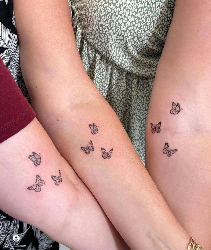 two women with matching tattoos on their arms, both have butterflies tattooed on the arm