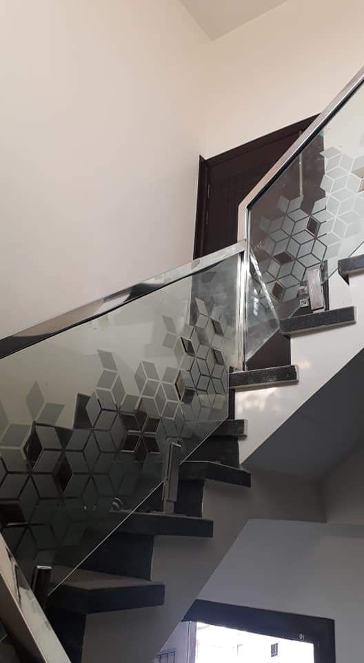 a stair case with glass railings and hexagonal tiles