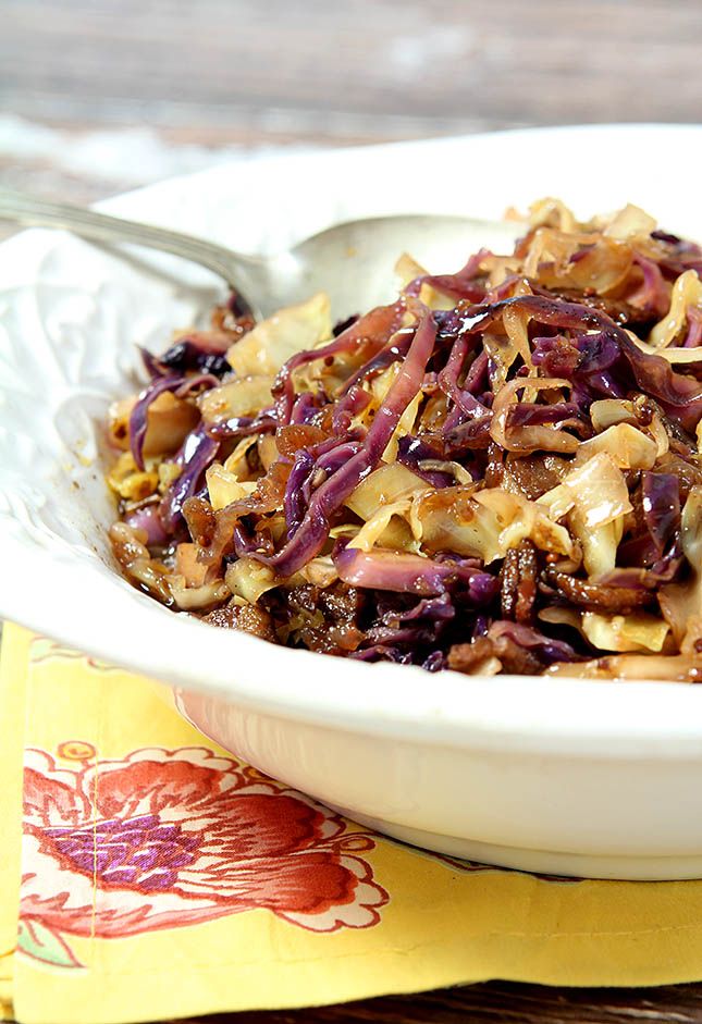 coleslaw with warm bacon dressing in a white bowl on top of a table