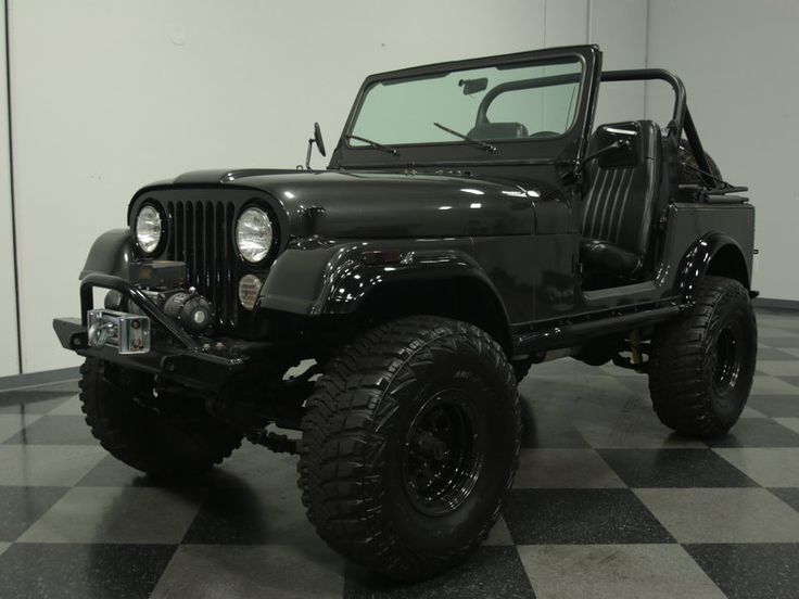 a black jeep is parked on a checkered floor