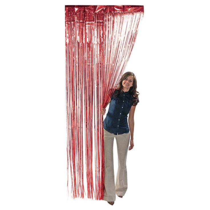 a woman standing next to a curtain with red streamers hanging from it's side