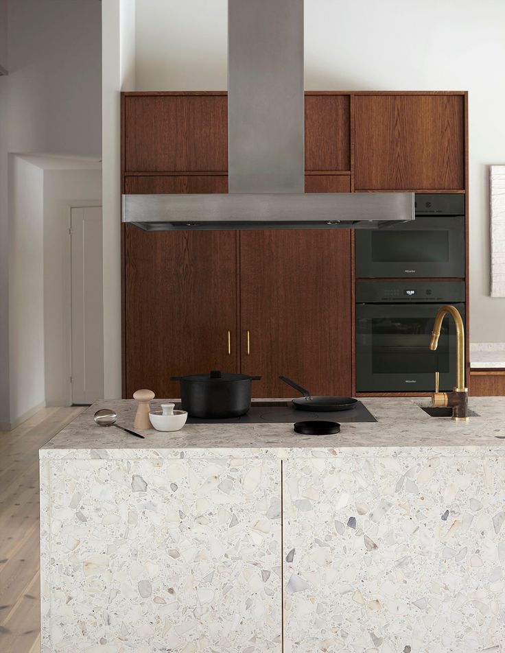 a modern kitchen with marble counter tops and wooden cabinetry is pictured in this image