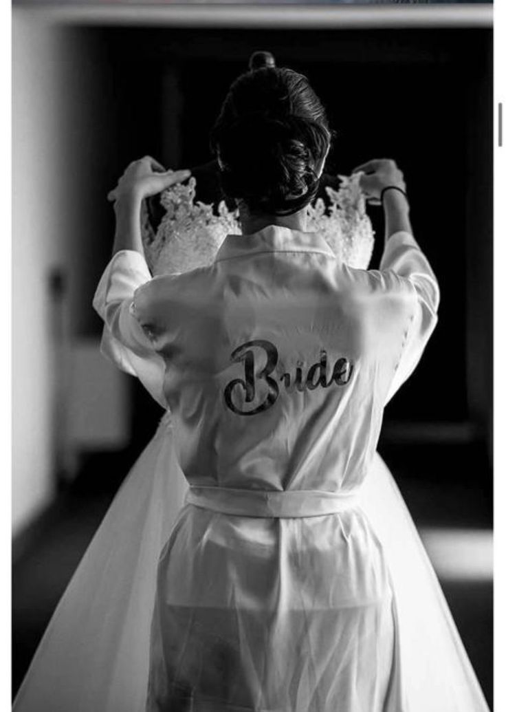 the back of a bride's dress as she stands in front of a doorway