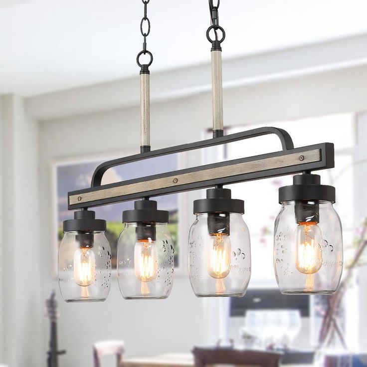 three mason jar chandelier hanging from the ceiling in a dining room or kitchen