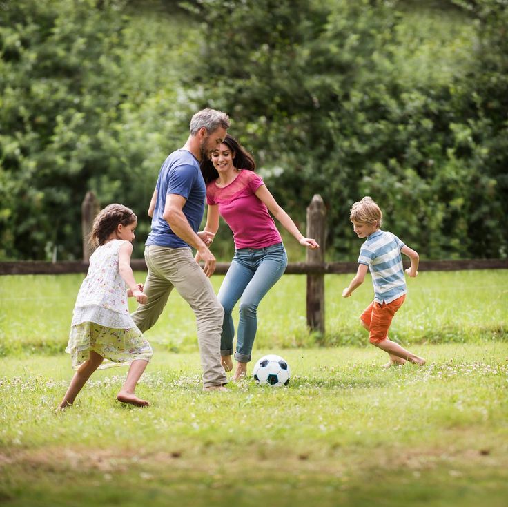 a family playing soccer in the park