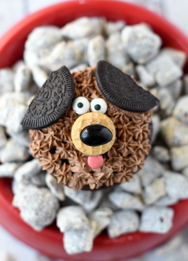 a bowl filled with cookies and oreos shaped like a dog's head on top of rocks