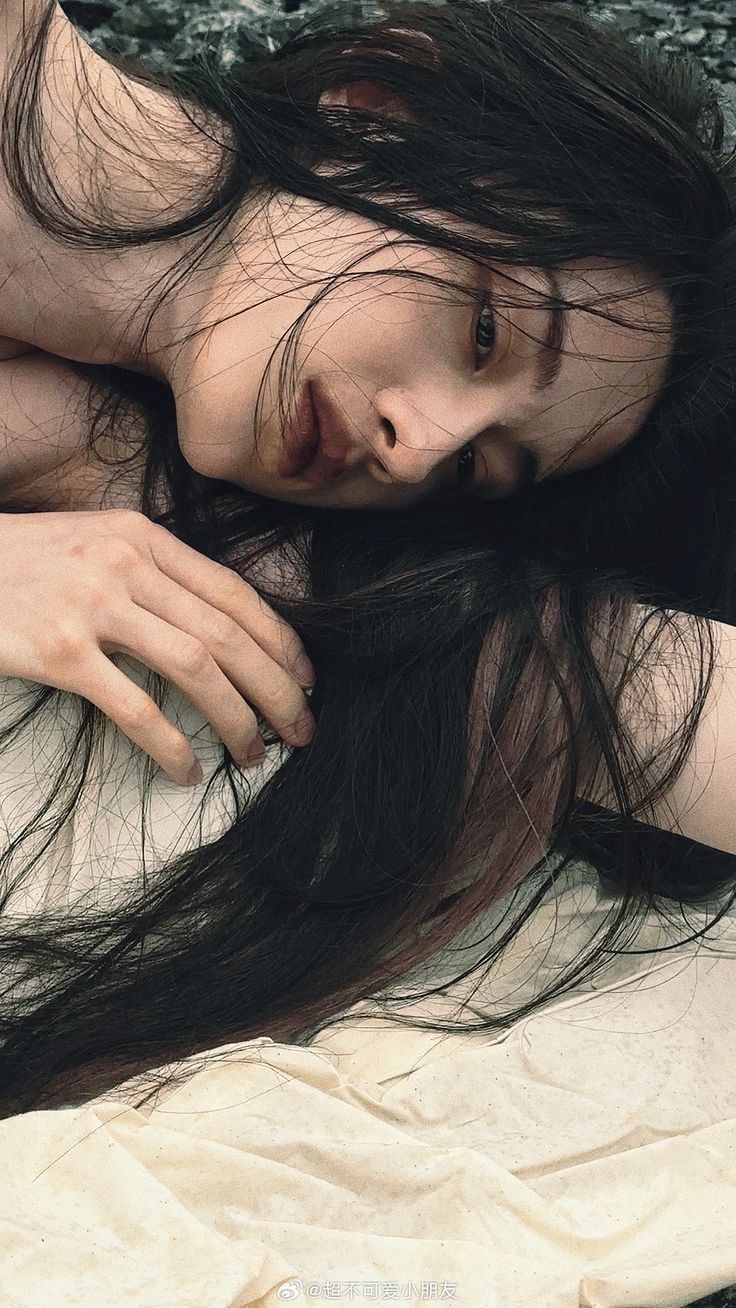 a woman laying on top of a bed covered in hair