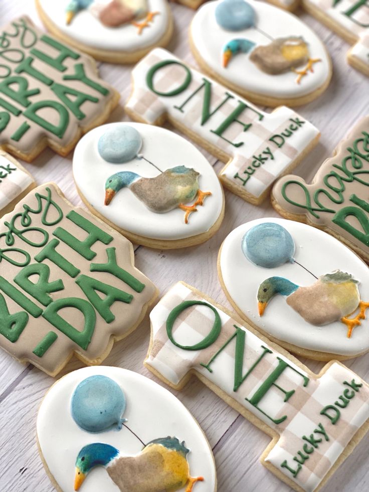 decorated cookies are arranged in the shape of birds and words that spell out happy birthday