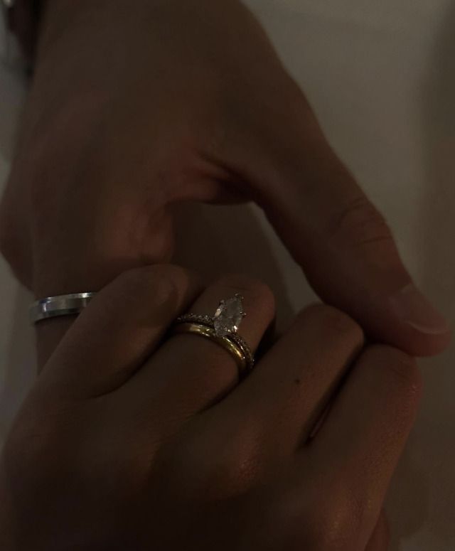 a woman's hand with two wedding rings on it