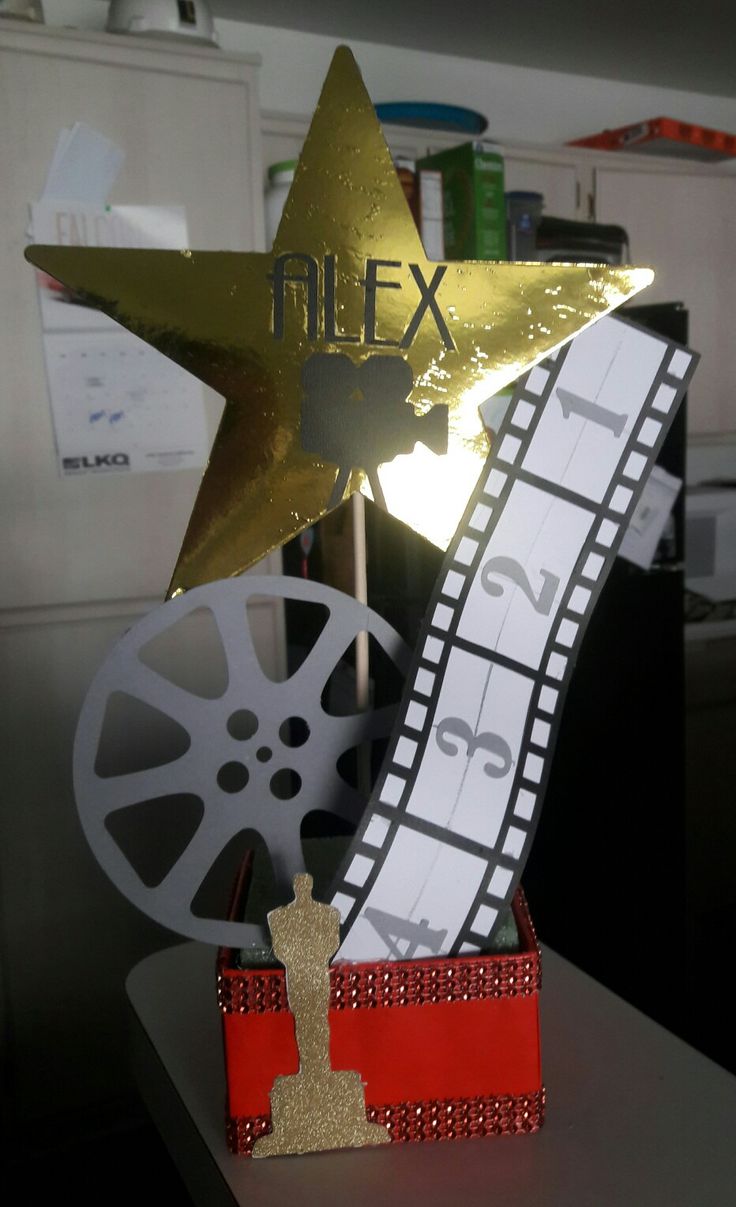 a golden star sitting on top of a wooden box next to a movie reel and clapper