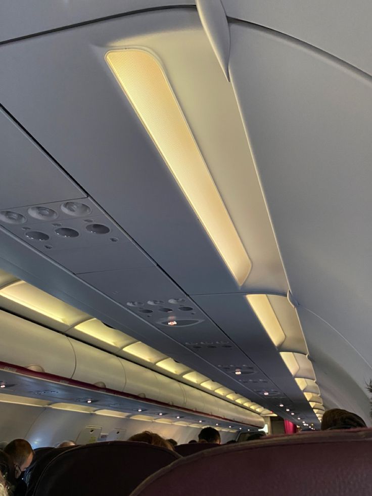 the inside of an airplane with people sitting on seats