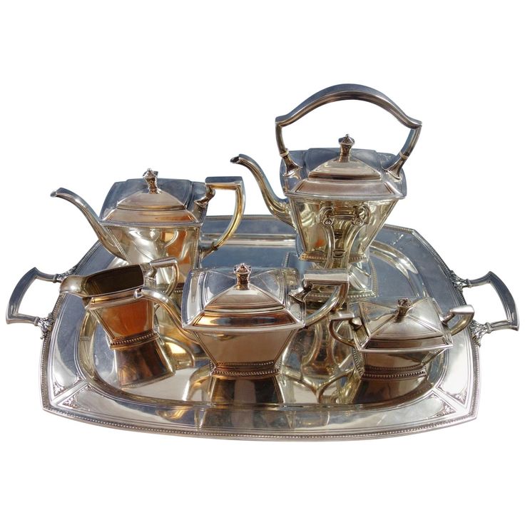 a silver tray with tea and coffee pots on it, set on top of each other