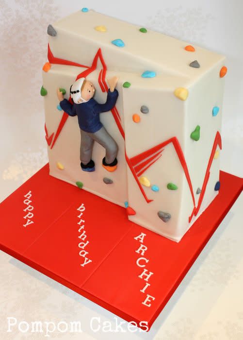 a birthday cake with a man climbing on it