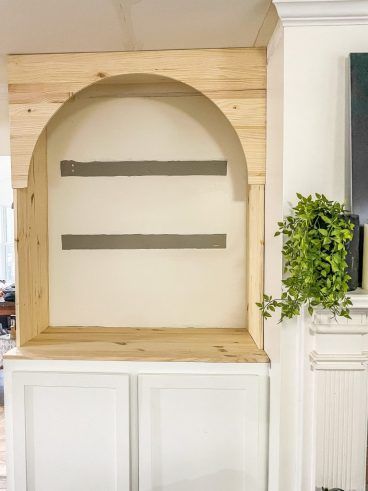 a white shelf with some plants in it and a potted plant sitting on top