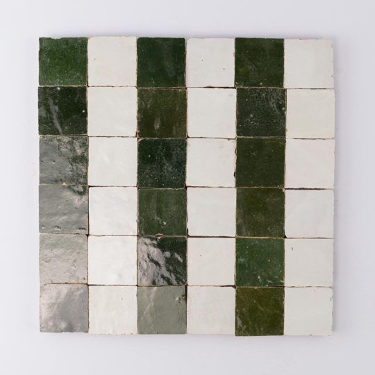 green and white tiles are arranged in rows on the wall, with one square at the center