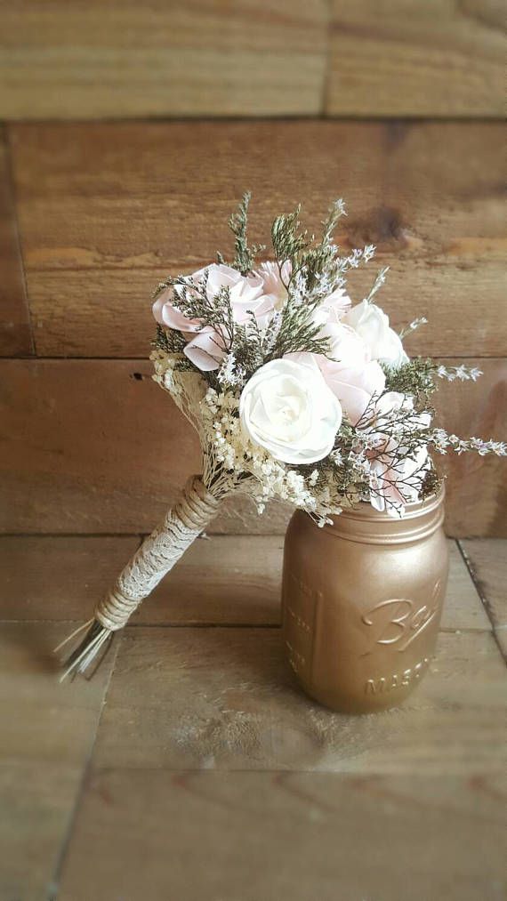 a mason jar filled with flowers on top of a wooden floor next to a wall