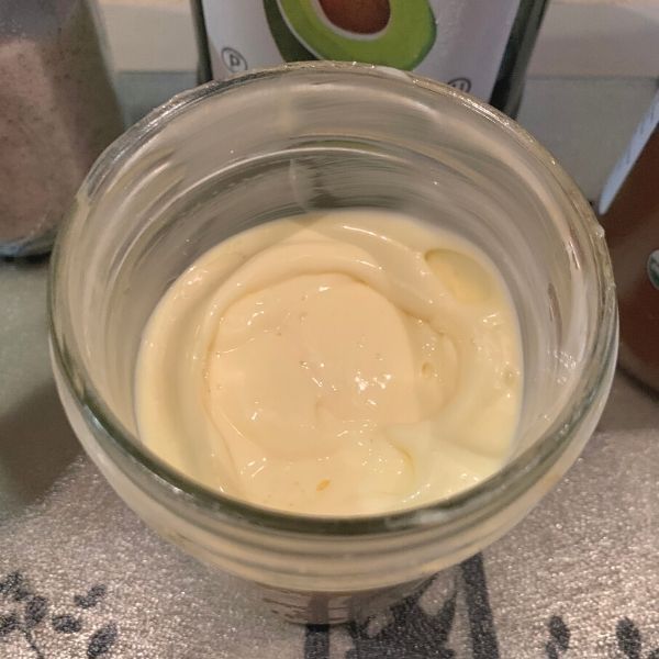 a glass bowl filled with cream sitting on top of a counter