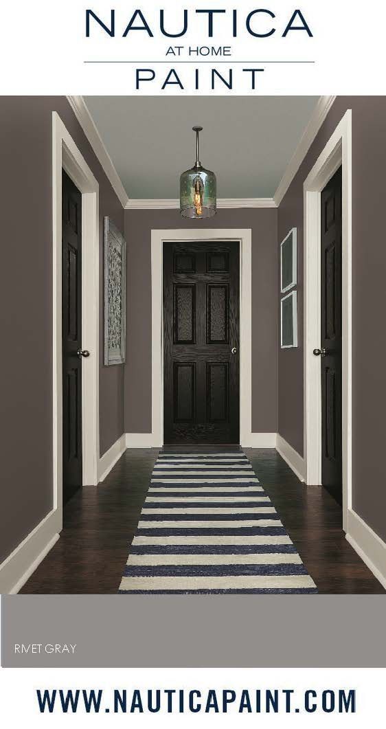 the hallway is painted in tauc and has an area rug that matches the door