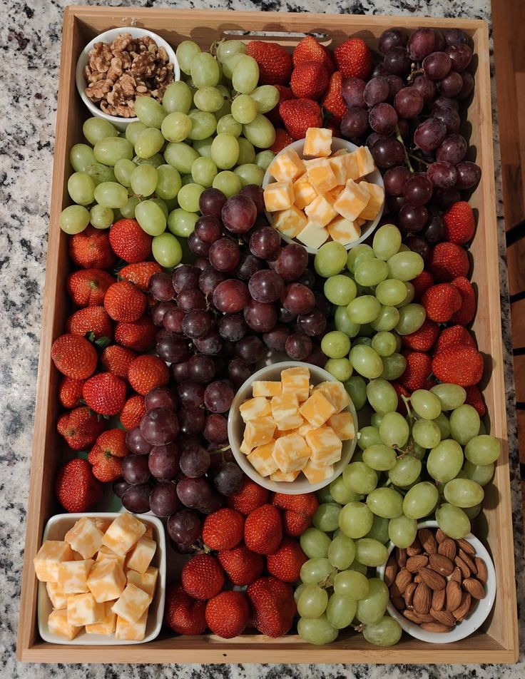 grapes, strawberries, walnuts, and other fruits are arranged in bowls