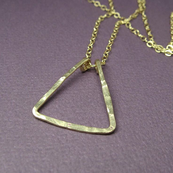 A small, elegant, lightly hammered, triangle hangs from your choice of 16, 18 inch cable chain. The triangle measures 7/8" (2.25 cm) tall and is handcrafted of 14K gold-fill. Cheap Triangle Statement Jewelry, Cheap Triangular Metal Jewelry, Cheap Trendy Triangle Jewelry, Long Triangle Necklace, Cheap Modern Triangle Jewelry, Luxury Triangle Yellow Gold Jewelry, Luxury Triangle Jewelry As Gift, Luxury Yellow Gold Triangle Jewelry, Gold Triangle Jewelry