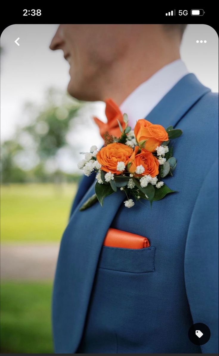 a man in a blue suit with an orange boutonniere