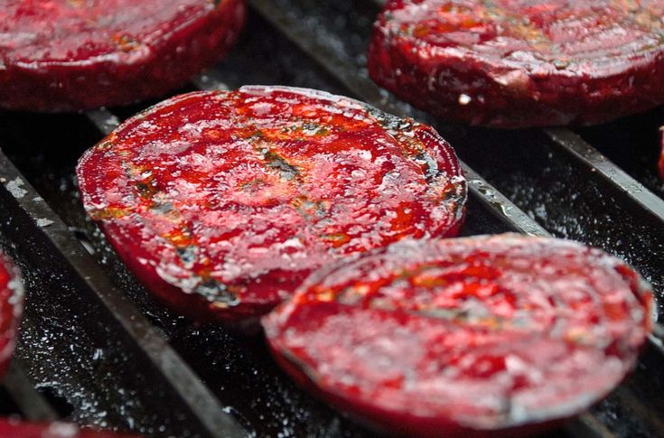 some red food is cooking on a grill