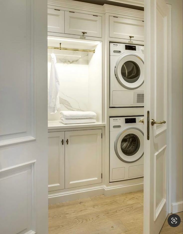 a white washer and dryer in a room next to each other with doors open