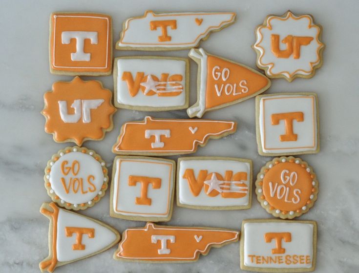 many decorated cookies are arranged in the shape of texas and tennessee on a marble surface